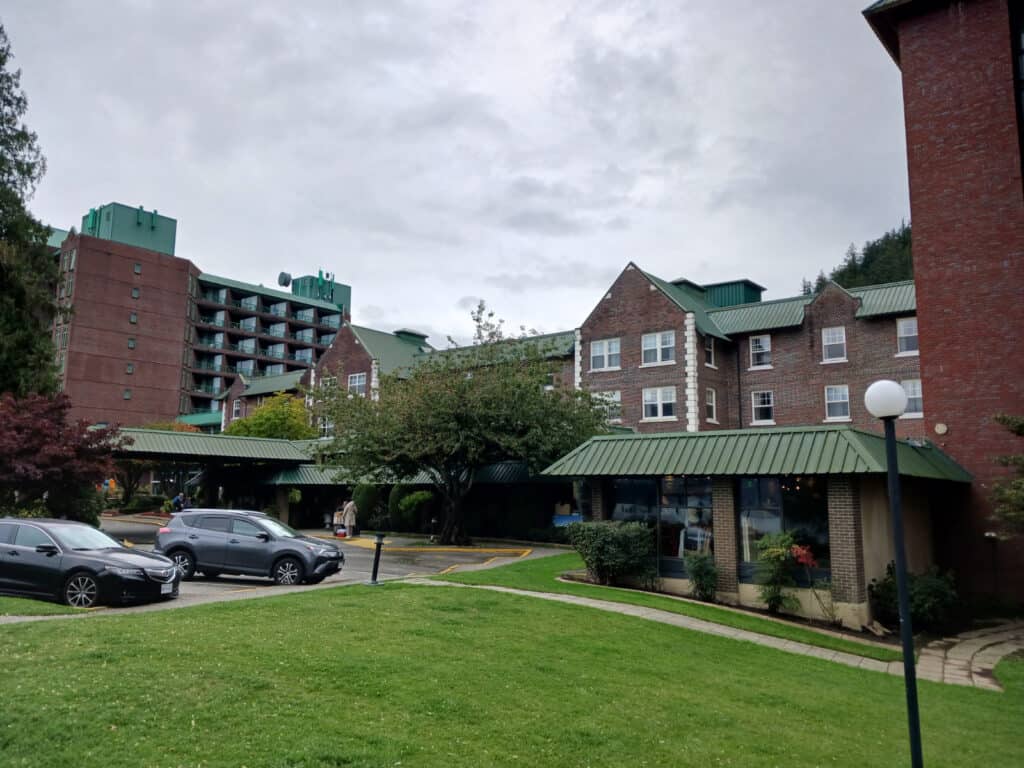 brick buildings of the Harrison Hot Springs Resort with green grass in foreground
