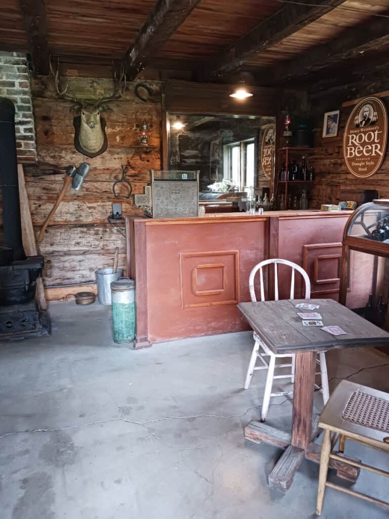 interior of saloon at Cashmere pioneer village with simple orange bar and antique cash register, table and two chairs in the foreground