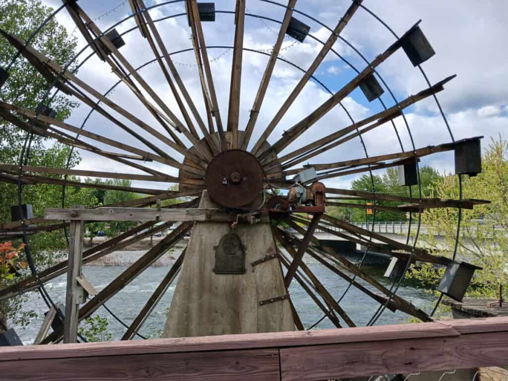 1891 wooden waterwheel fills the frame with wenatchee river in the background